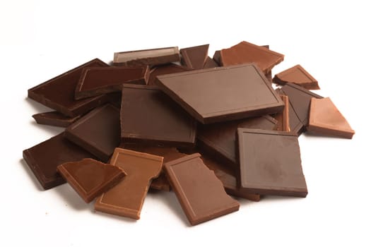 Broken different chocolate bars in many colors and flavors isolated on white background
