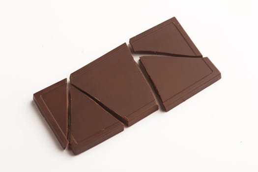Top view of broken chocolate bar pieces isolated on white background