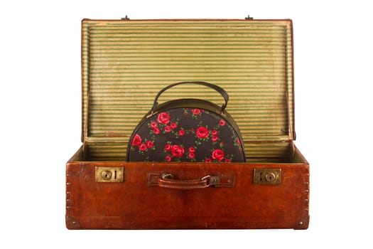 Old vintage open suitcase with roses themed hand luggage isolated on white background