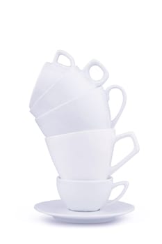 Front view of white ceramic coffee cups piled up on a dish and isolated