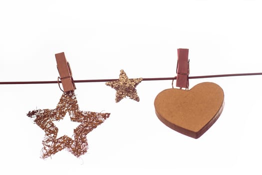 Christmas decorations, stars and cardboard heart with wooden peg on a line isolated on white