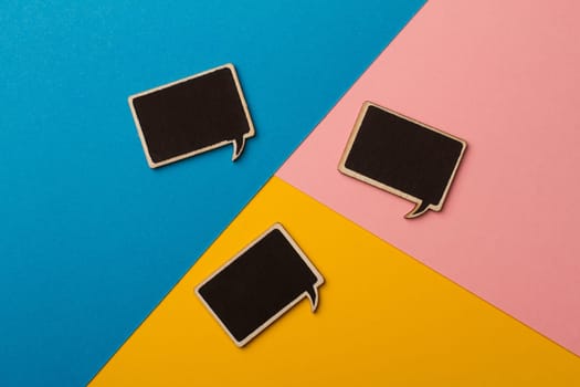 Top view of square chalk board speech bubbles on colored papers, metaphor, concept for communication