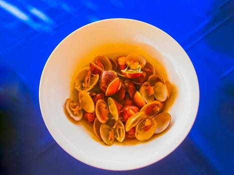 Fresh oysters in a white plate on a blue background
