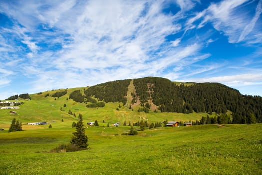 panoramic view of the Seiser Alm in a sunny day with blue sky and clouds