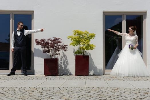 Young bridal couple has fun - point their hands to each other