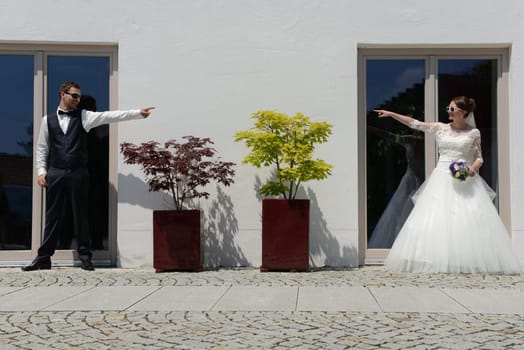 Young bridal couple has fun - point their hands to each other