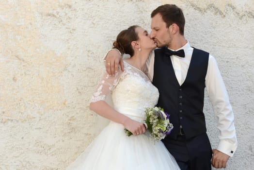 Bridal couple in love kisses