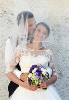 Happy young couple with bridal bouquet
