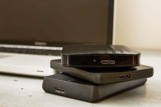 External Hard Disks and Laptop Keyboard on Wooden Table.