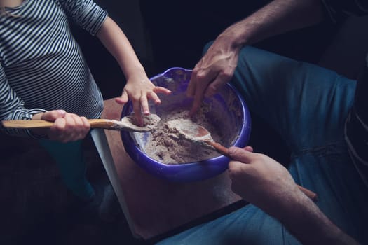 Top view of father and daughter working the dough of a bread together