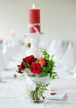 Bridal bouquet and candle on the wedding table