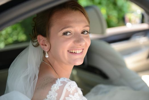 Bride in the bridal car with a view into the camera
