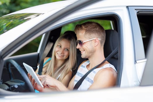 Young happy people enjoying a roadtrip in the car