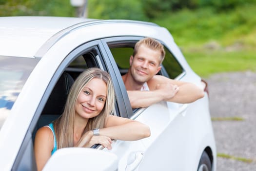 Young happy people enjoying a roadtrip in the car