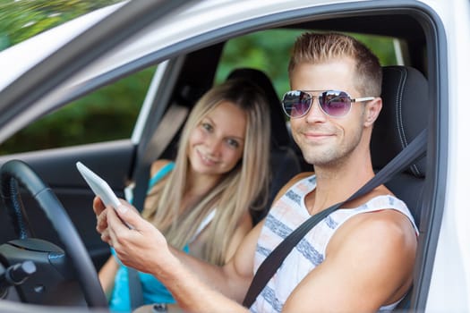 Young happy people enjoying a roadtrip in the car