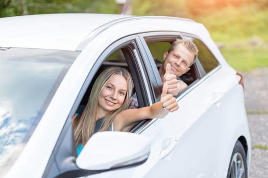 Young happy people enjoying a roadtrip in the car