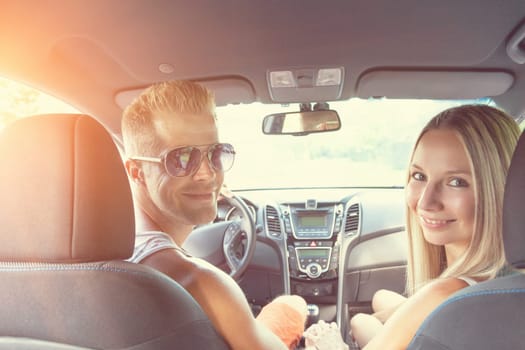 Young happy people enjoying a roadtrip in the car