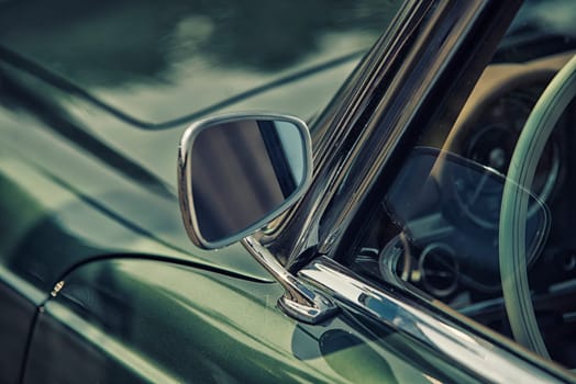 close up on rear view mirror on greenv intage car.