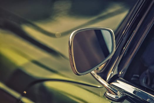 close up on rear view mirror on greenv intage car.