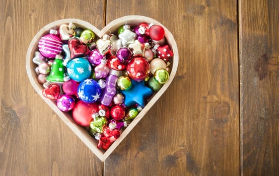 Various colorful Christmas tree balls in one heart shape