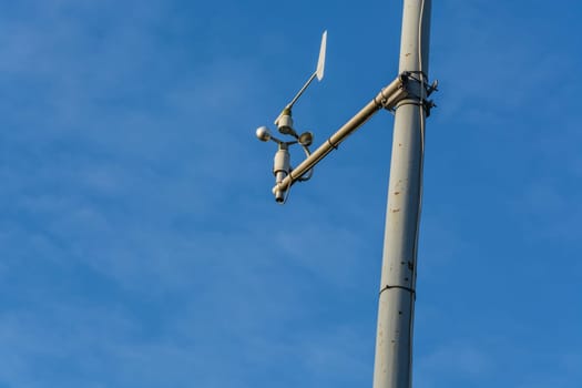Weather station with anemometer on a blue sky..
