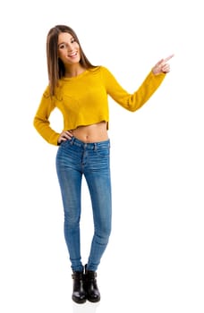 Beautiful and happy teenage girl pointing, isolated over white background