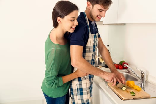 Young couple on the kitchen follow a recipe by tablet and cooking