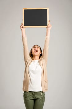 Beautiful and happy woman holding and showing a chalkboard very high