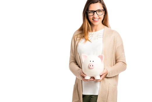 Beautiful and happy woman holding a piggy bank and making thumb up