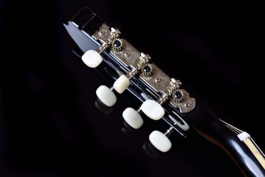 Head of an acoustic guitar with tuning machine heads and tuning pegs