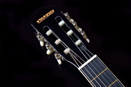 Head of an acoustic guitar with tuning machine heads and tuning pegs