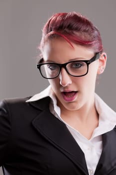 redhaired sexy eighties secretary with glasses staring at camera with some artifice