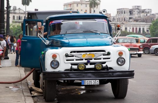 cuban man is driving the old classic lorry along the street at the Old Havana