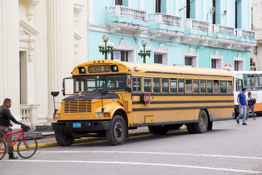 Typical old classic north amrican school bus parked along the street in Santa Clara, Cuba