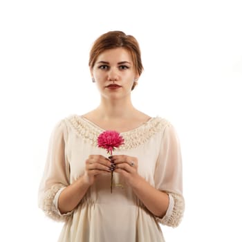 A young woman in a white dress holding a flower