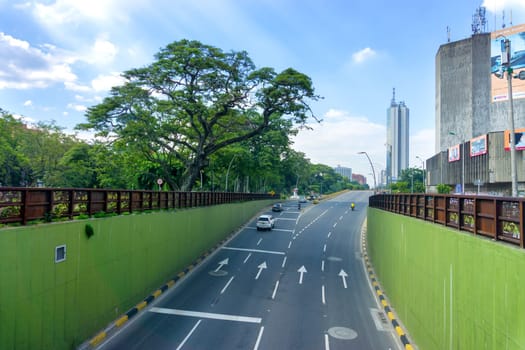 CALI, COLOMBIA - JUNE 11: Highway leading to modern skyscraper in Cali, Colombia on June 11, 2016