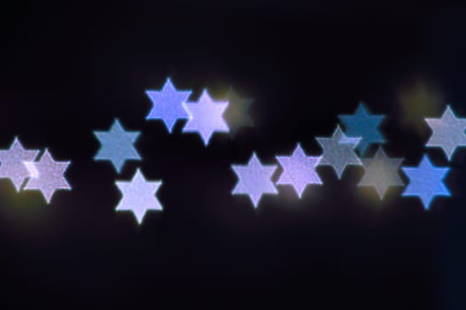 Beautiful bokeh lights in shape of the Star of David for Hanukkah celebration. Jewish Holiday background.