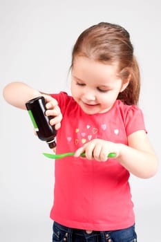 Cute Baby Girl Drinking Medicine Syrup - Stock image