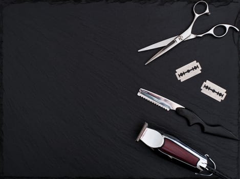 Barber shop equipment on Black background with place for text.  Professional hairdressing tools. Comb, scissor, clippers and hair trimmer isolated.