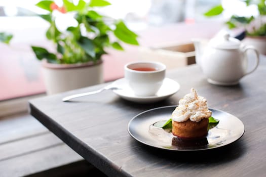 Breakfast time . Tea and cake with cream, garnished with mint leaves