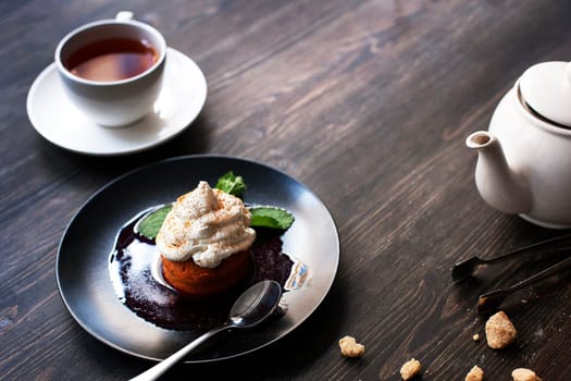Breakfast time . Tea and cake with cream, garnished with mint leaves.