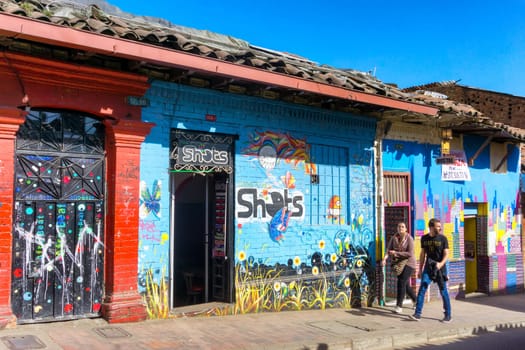 BOGOTA, COLOMBIA - APRIL 21: Pedestrians walk down a colorful street in Bogota, Colombia on April 21, 2016