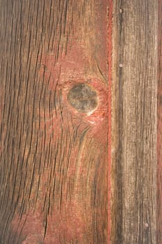 Looking at a crack in the wood plank barn wall with a big knot
