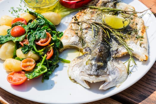 Fresh fish sea bream,sea bream prepared with salt,herbs and pepper,grilled..