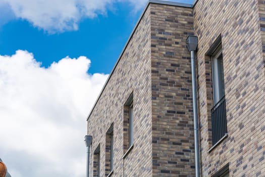 Upper floor of a modern residential building in bungalow style with flat roof in front of blue sky..