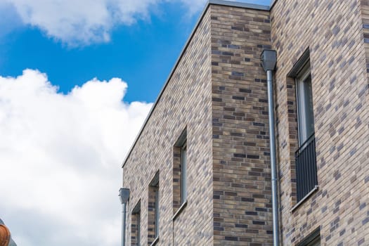 Upper floor of a modern residential building in bungalow style with flat roof in front of blue sky..