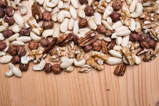 different nuts on wooden ground from above