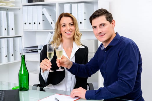 young businessman and businesswoman celebrating together in the office