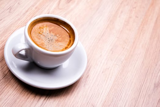 cup of coffee on wooden table from above