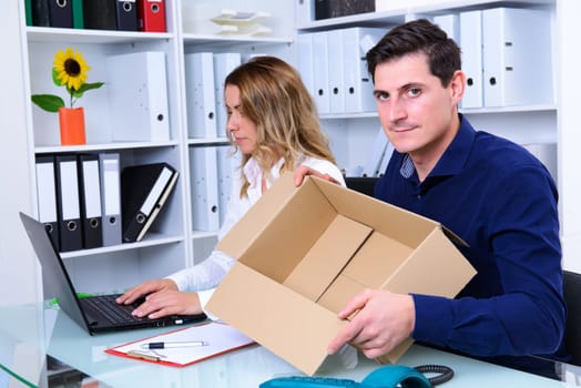 young businessman and businesswoman with empty delivery box in the office